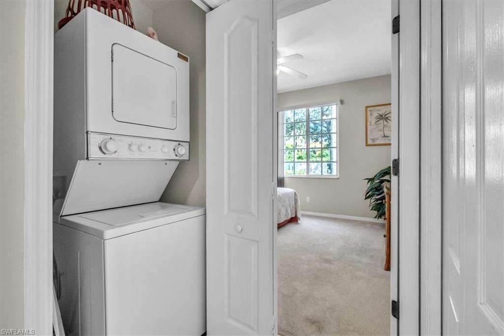 8075 Tiger Cove, Unit 1706 Naples, FL 34113 - Photo 31 of 50 Washroom featuring light carpet, stacked washer and clothes dryer, and a ceiling fan