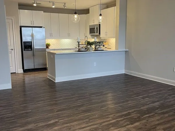 a kitchen with granite countertop a sink and refrigerator