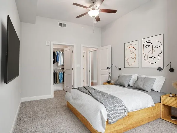 a bedroom with a large bed and a chandelier
