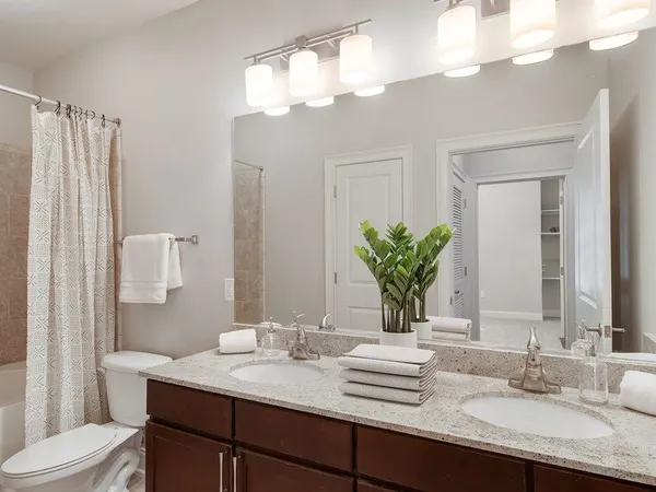 a bathroom with a granite countertop sink a toilet and mirror