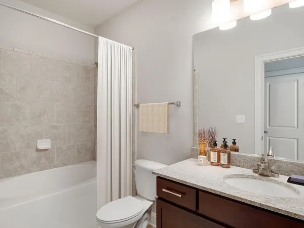 a bathroom with a granite countertop sink toilet and shower