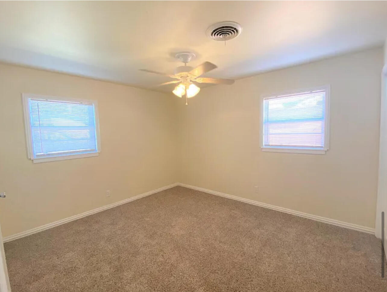 4908 43rd Street Lubbock, TX 79414 - Photo 12 of 18 an empty room with a window and a fan