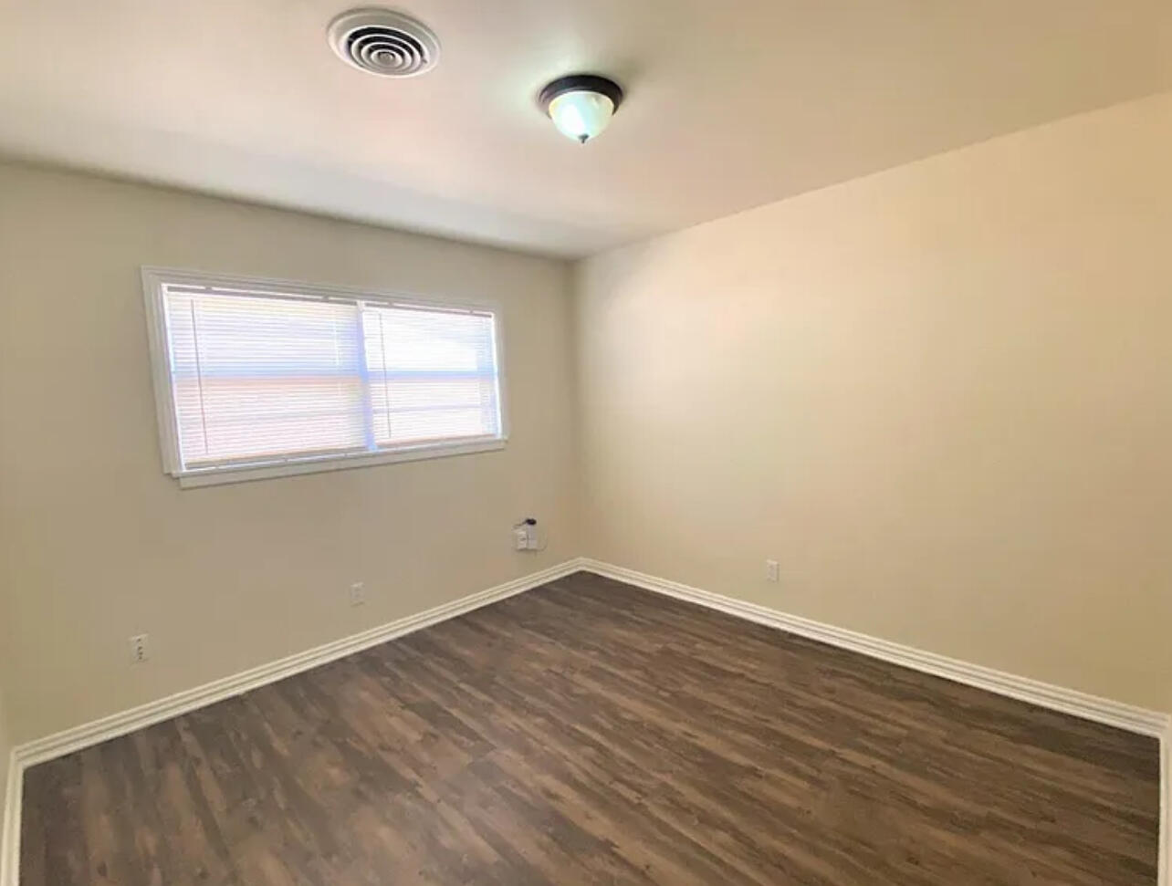 4908 43rd Street Lubbock, TX 79414 - Photo 15 of 18 an empty room with wooden floor and windows