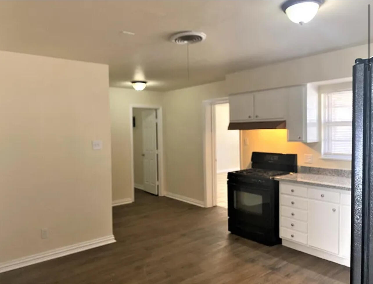 4908 43rd Street Lubbock, TX 79414 - Photo 4 of 18 a kitchen with a refrigerator and window