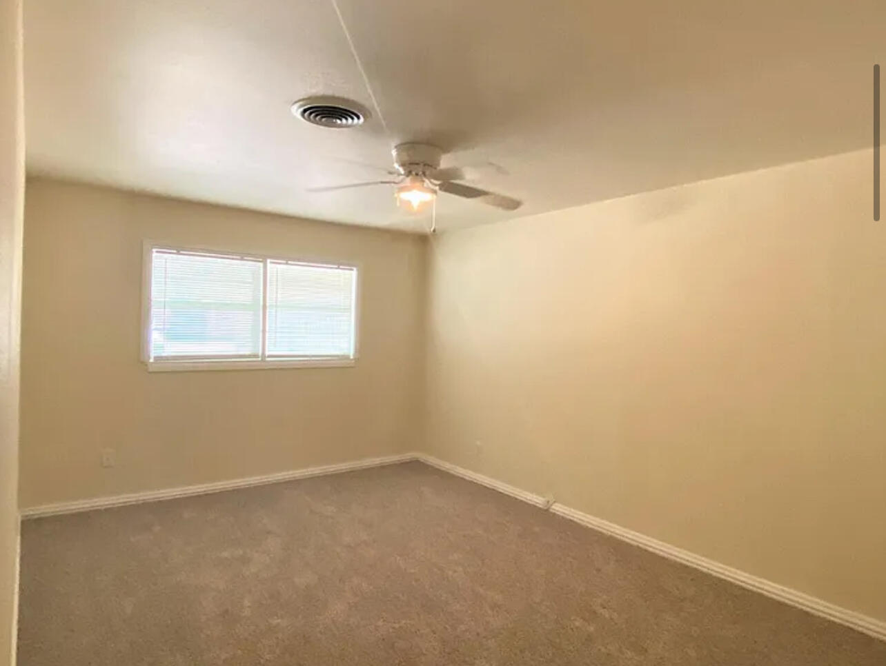 4908 43rd Street Lubbock, TX 79414 - Photo 7 of 18 an empty room with a window and a fan