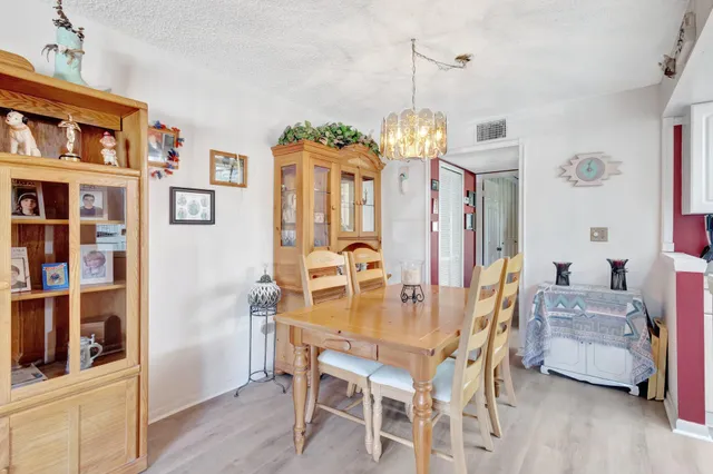 a view of a dining room with furniture and a chandelier