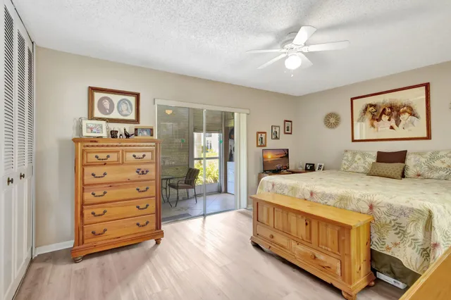 a bedroom with a bed a dresser and painting on the wall