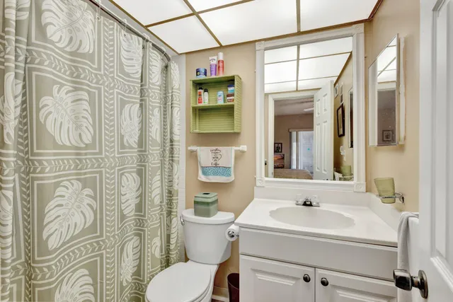 a bathroom with a sink and mirror with toilet