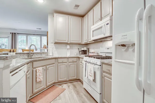 a kitchen with stainless steel appliances granite countertop a lot of cabinets and wooden floor
