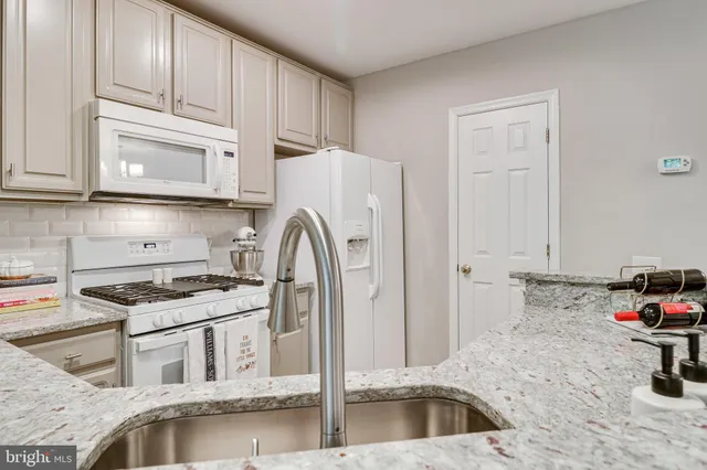 a kitchen with stainless steel appliances granite countertop a refrigerator sink and stove