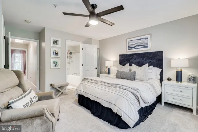 a spacious bedroom with a bed a lamp and a chandelier
