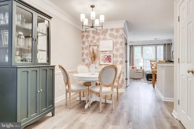 a view of a dining room with furniture a chandelier and wooden floor