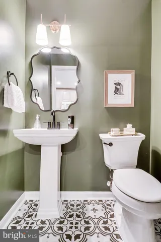 a bathroom with a toilet sink and mirror
