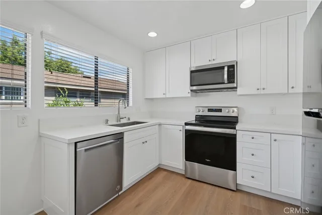 a kitchen with granite countertop a sink and steel appliances