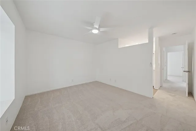 an empty room with a ceiling fan and bathroom