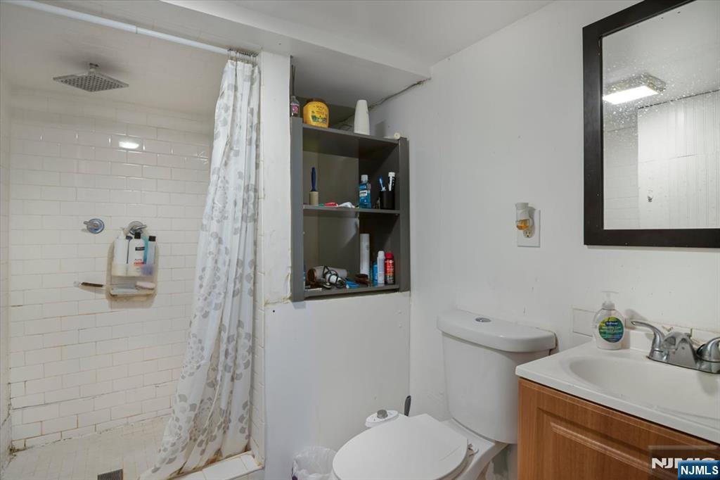 22 Tuttle Street Wallington, NJ 07057 - Photo 17 of 33 a bathroom with a granite countertop sink a toilet and shower