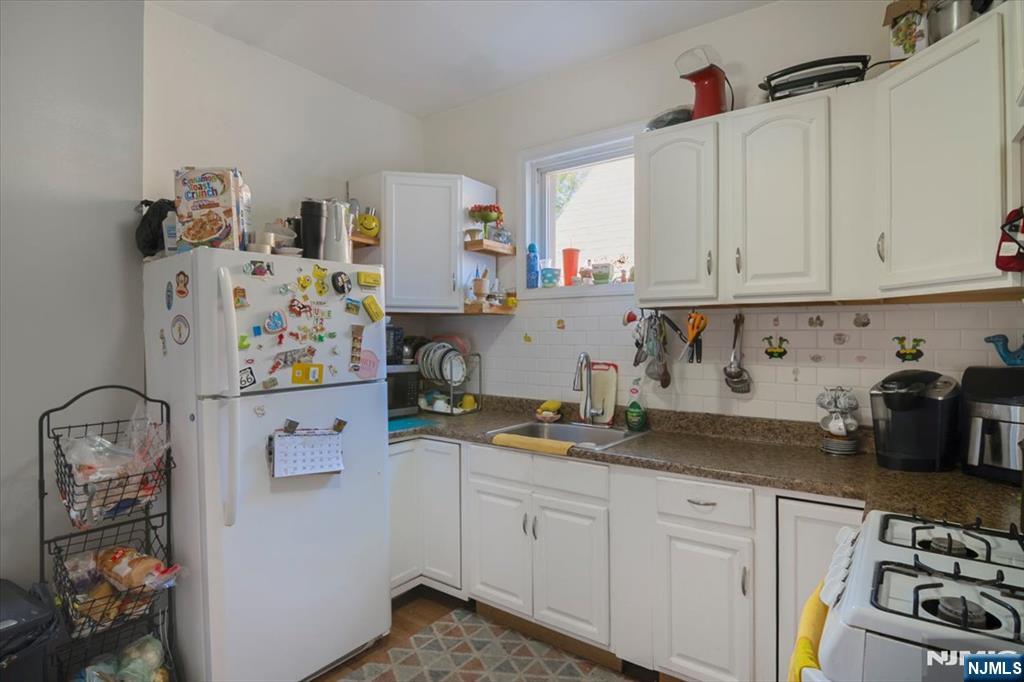 22 Tuttle Street Wallington, NJ 07057 - Photo 24 of 33 a kitchen with refrigerator and cabinets