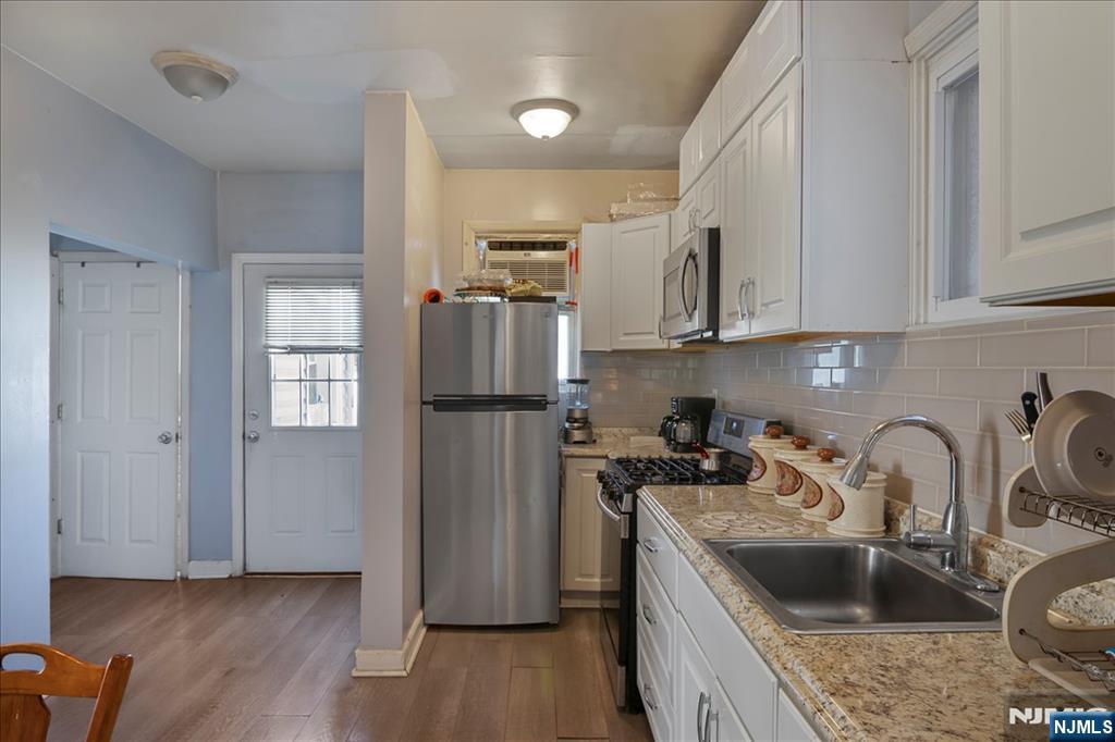 22 Tuttle Street Wallington, NJ 07057 - Photo 10 of 33 a kitchen with stainless steel appliances granite countertop a refrigerator sink and wooden cabinets