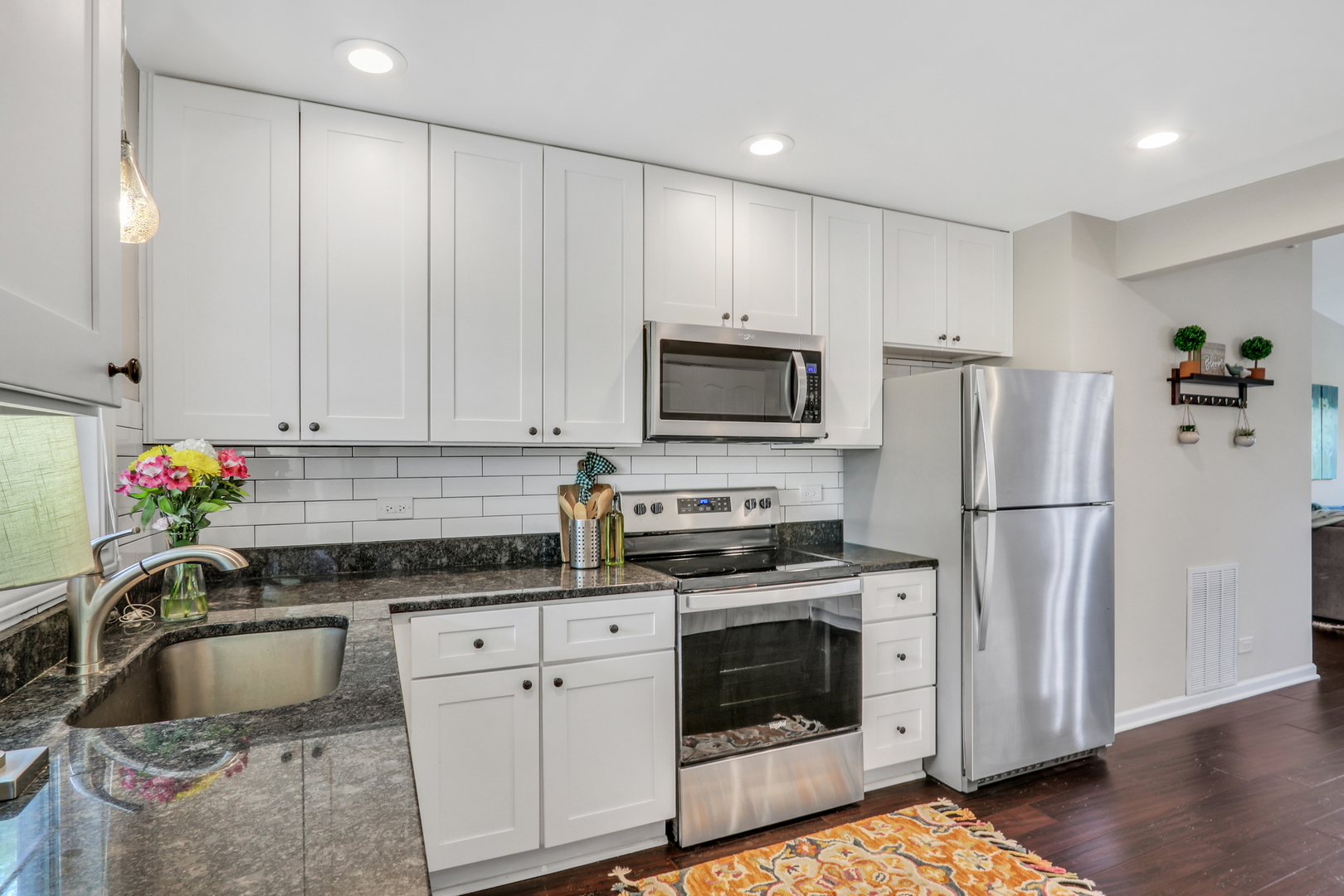 104 East Winchester Road, Unit E Libertyville, IL 60048 - Photo 9 of 23 a kitchen with granite countertop white cabinets and white stainless steel appliances