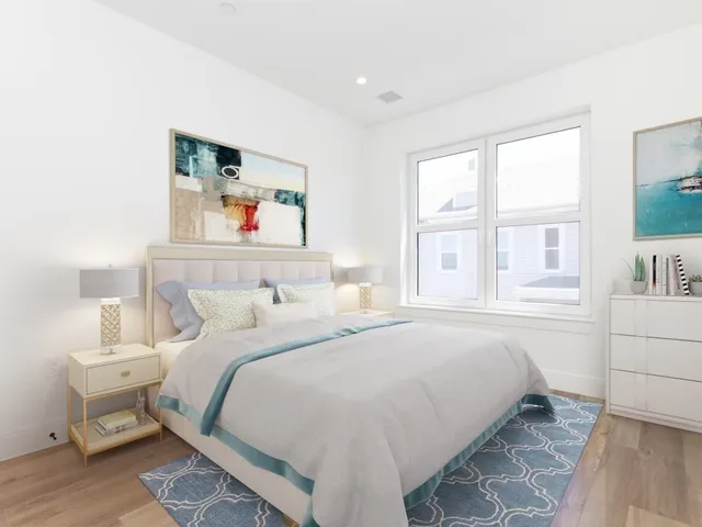 a bedroom with a bed and a large window