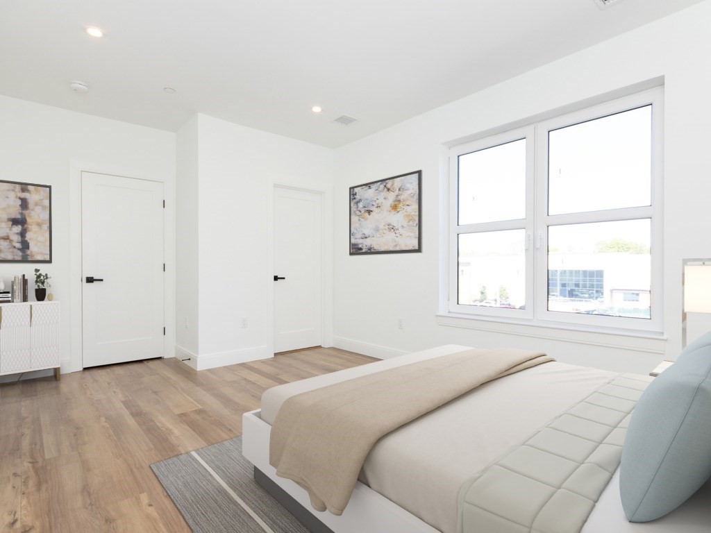 2 Neponset, Unit 3 Boston, MA 02122 - Photo 5 of 8 a bedroom with a bed and a large window