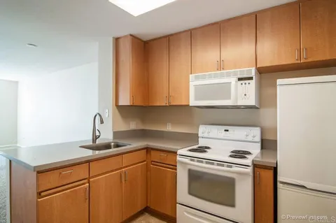 a kitchen with appliances cabinets and a counter top space