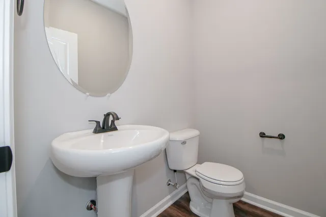 a bathroom with a sink a toilet and mirror