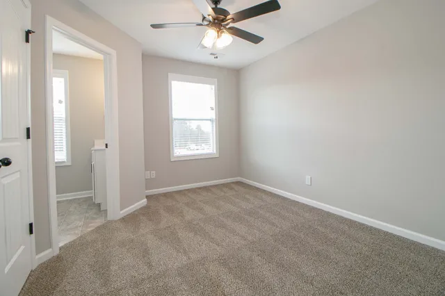 an empty room with fan and windows