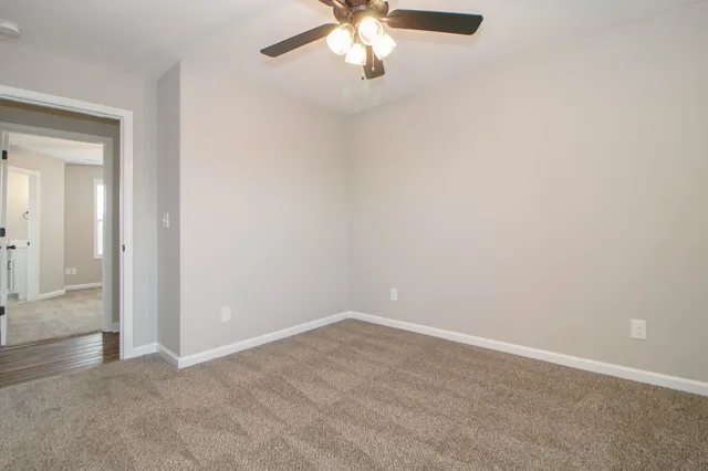 en empty room with windows and ceiling fan