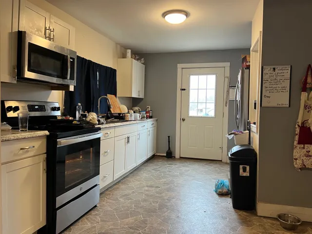 a kitchen with stainless steel appliances granite countertop a stove a sink and a refrigerator