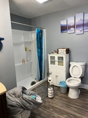 a bathroom with a granite countertop toilet and a sink