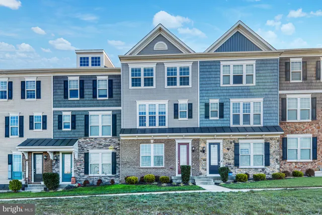 a front view of a house with yard and green space