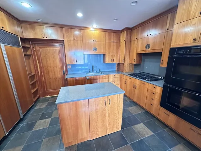 a kitchen with stainless steel appliances granite countertop a refrigerator and a stove