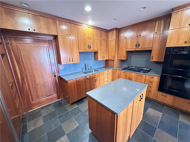 a kitchen with stainless steel appliances a stove a sink and a refrigerator