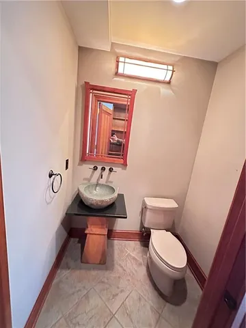 a bathroom with a toilet a sink and mirror