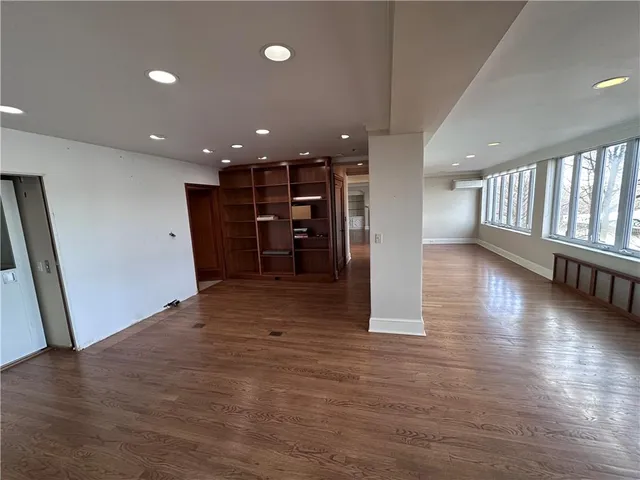 an empty room with wooden floor and staircase
