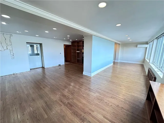 a view of an empty room with wooden floor