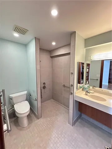 a bathroom with a toilet sink double vanity and mirror