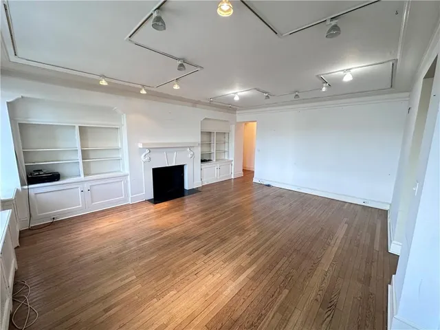 an empty room with wooden floor and fireplace