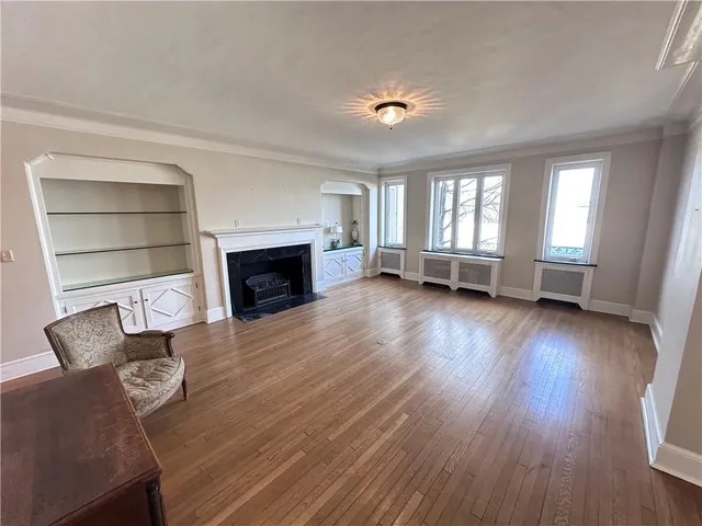 wooden floor fireplace and windows in an empty room