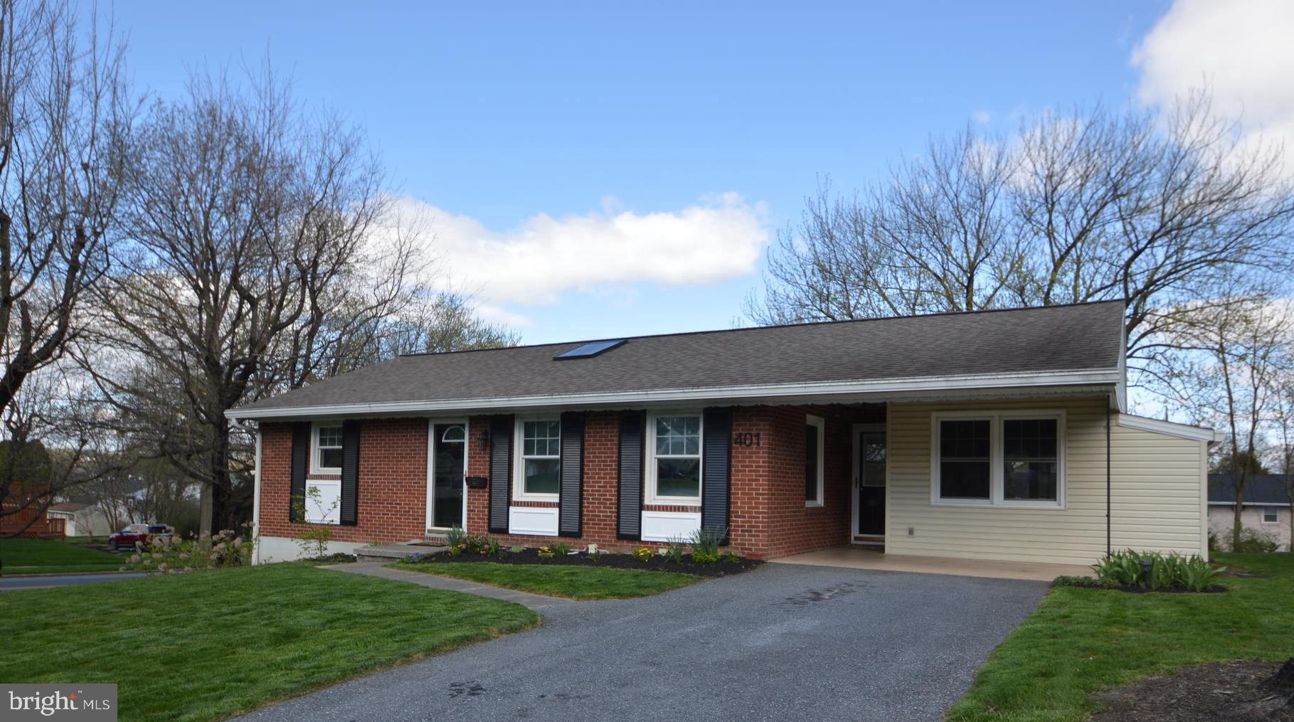 a front view of a house with a yard and trees