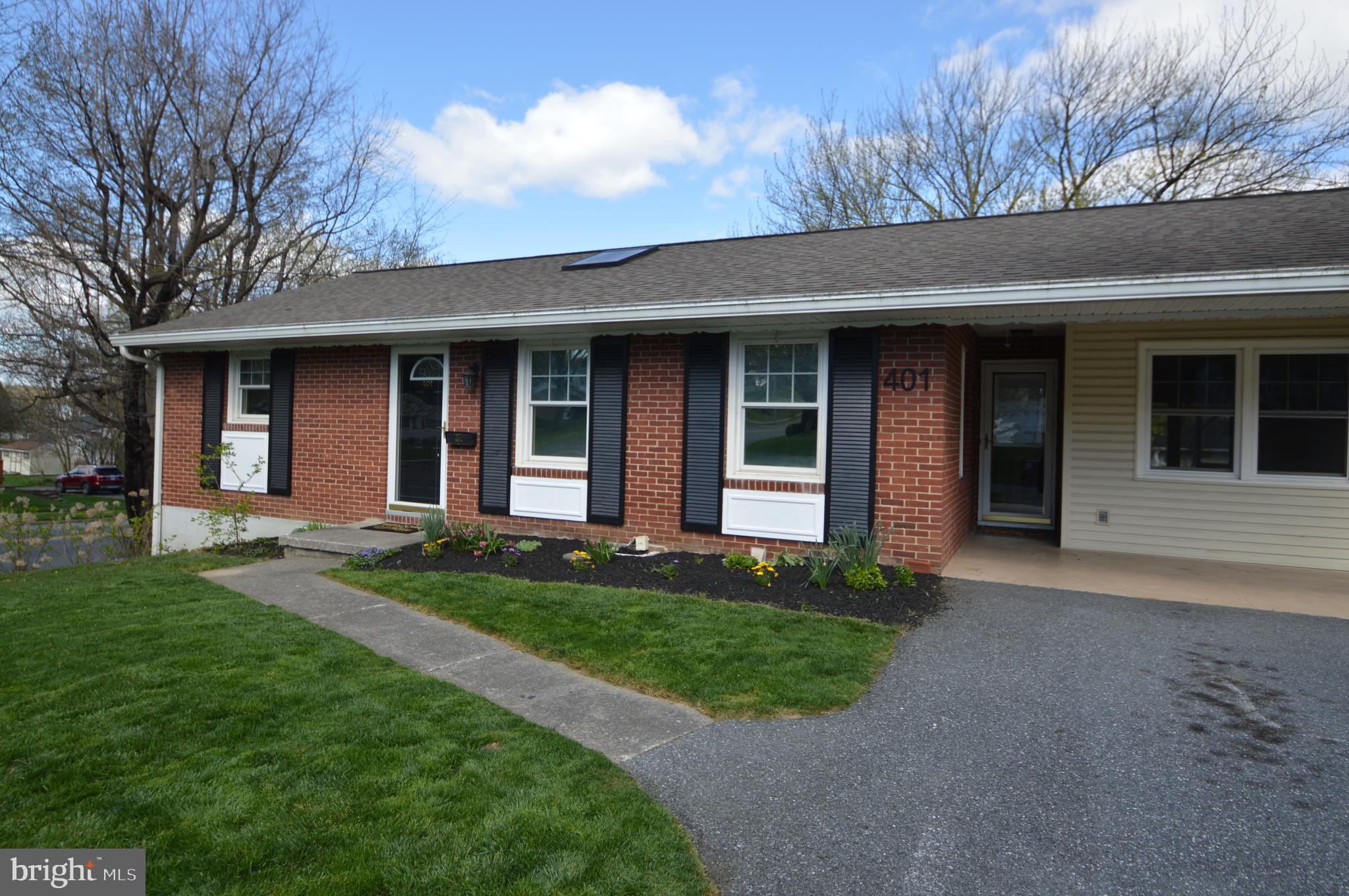 401 Lemon Street Elizabethtown, PA 17022 - Photo 3 of 39 a view of a brick house with a large windows and a yard with plants and large trees