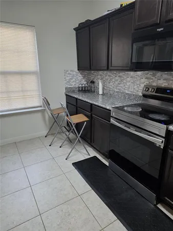 a kitchen with granite countertop a stove and a microwave