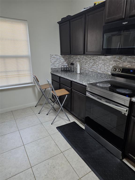 3009 Earl Road Anna, TX 75409 - Photo 4 of 9 a kitchen with granite countertop a stove and a microwave