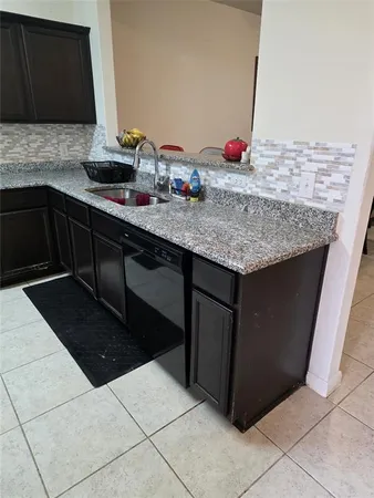 a kitchen with granite countertop sink and cabinets