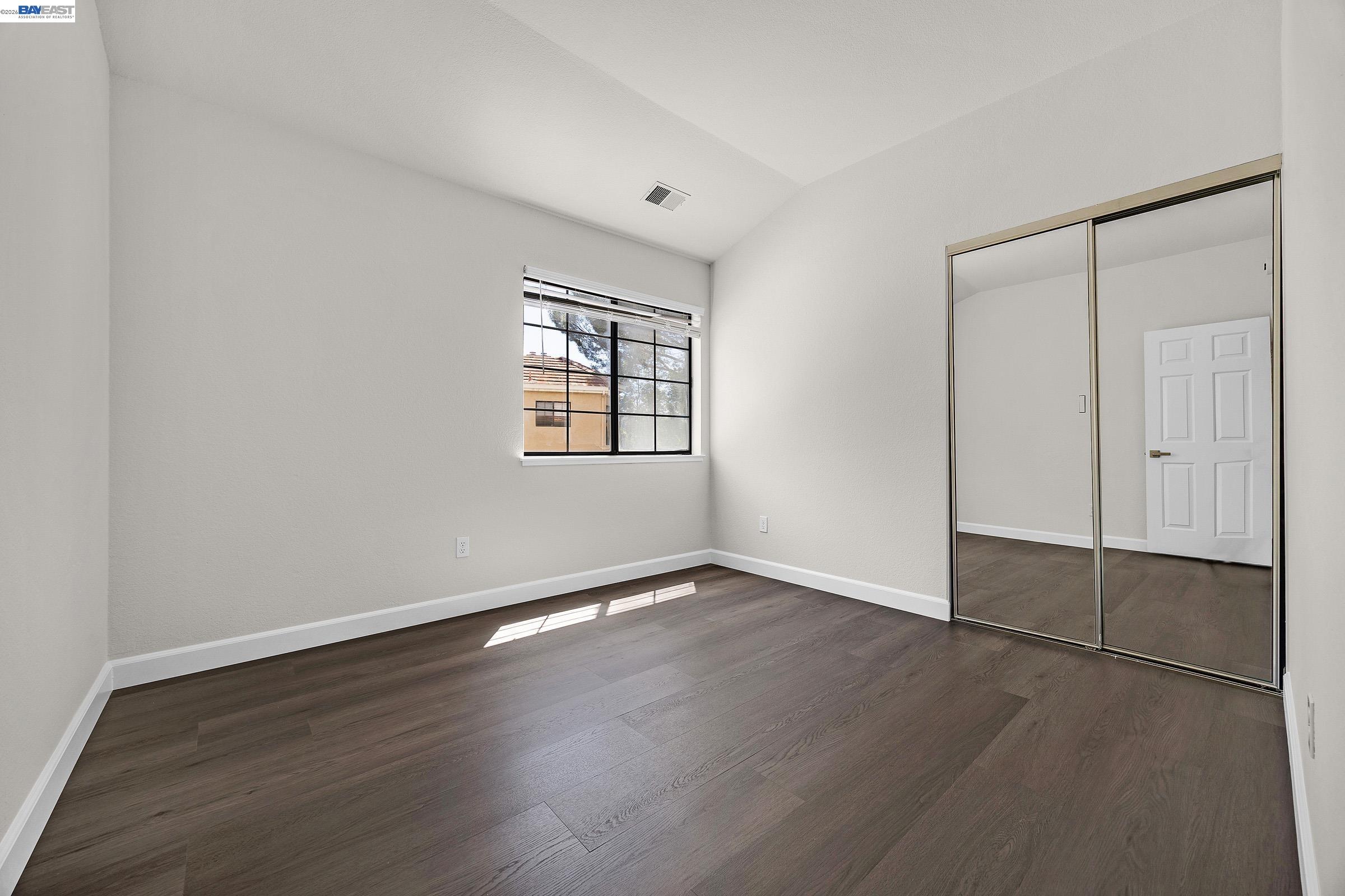 5012 Lakeview Drive, Unit 200 San Ramon, CA 94582 - Photo 22 of 47 an empty room with wooden floor and windows