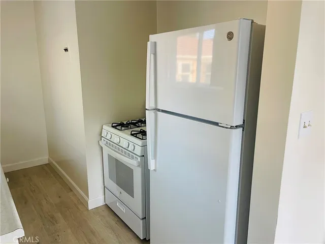 a white refrigerator freezer and a stove sitting inside of a kitchen