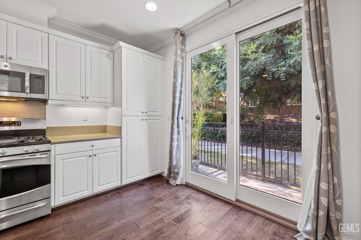 Undisclosed Address Bakersfield, CA 93306 - Photo 20 of 54 a kitchen with white cabinets and wooden floor