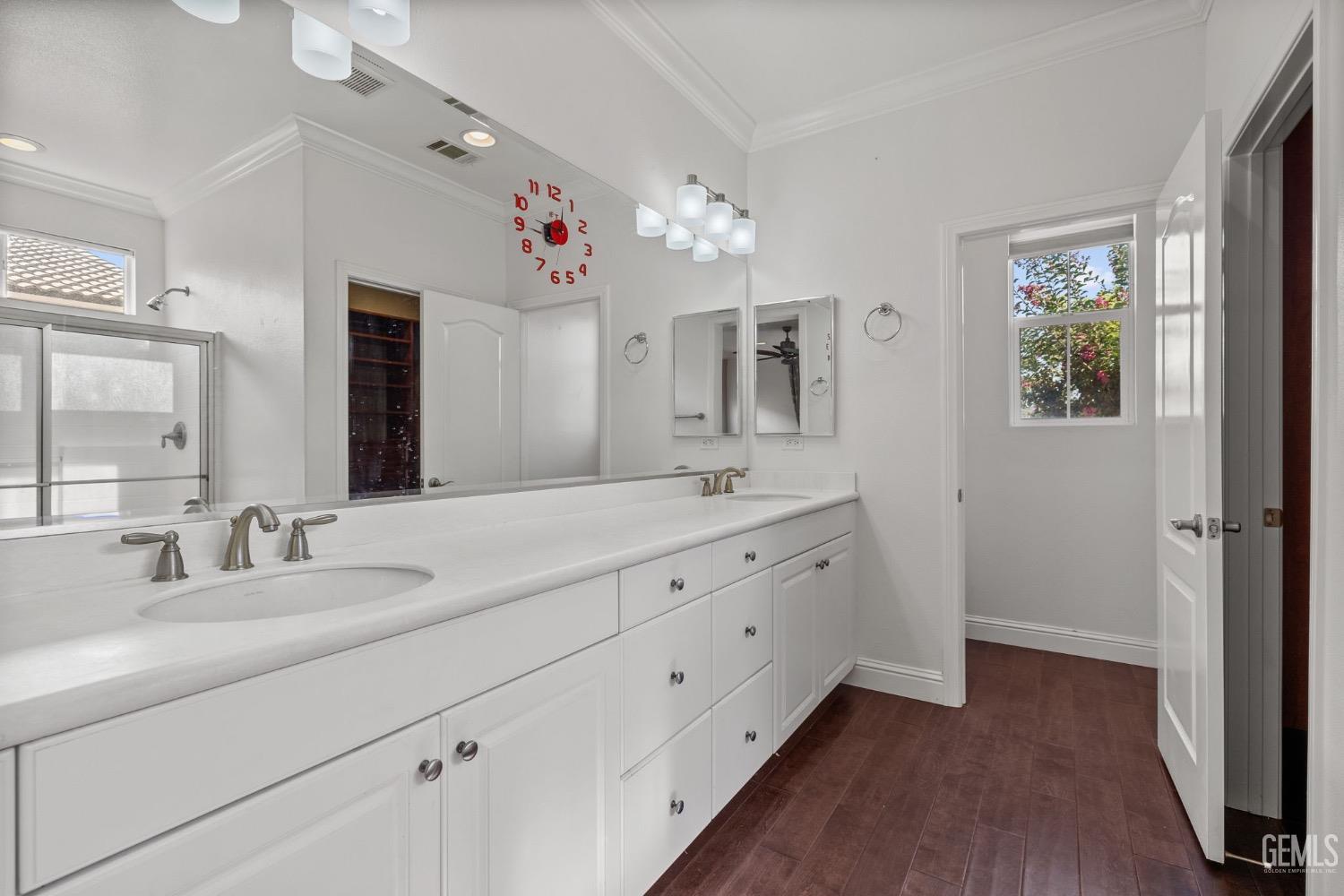 Undisclosed Address Bakersfield, CA 93306 - Photo 25 of 54 a spacious en suite bathroom with a double vanity sink a large mirror a shower and a window