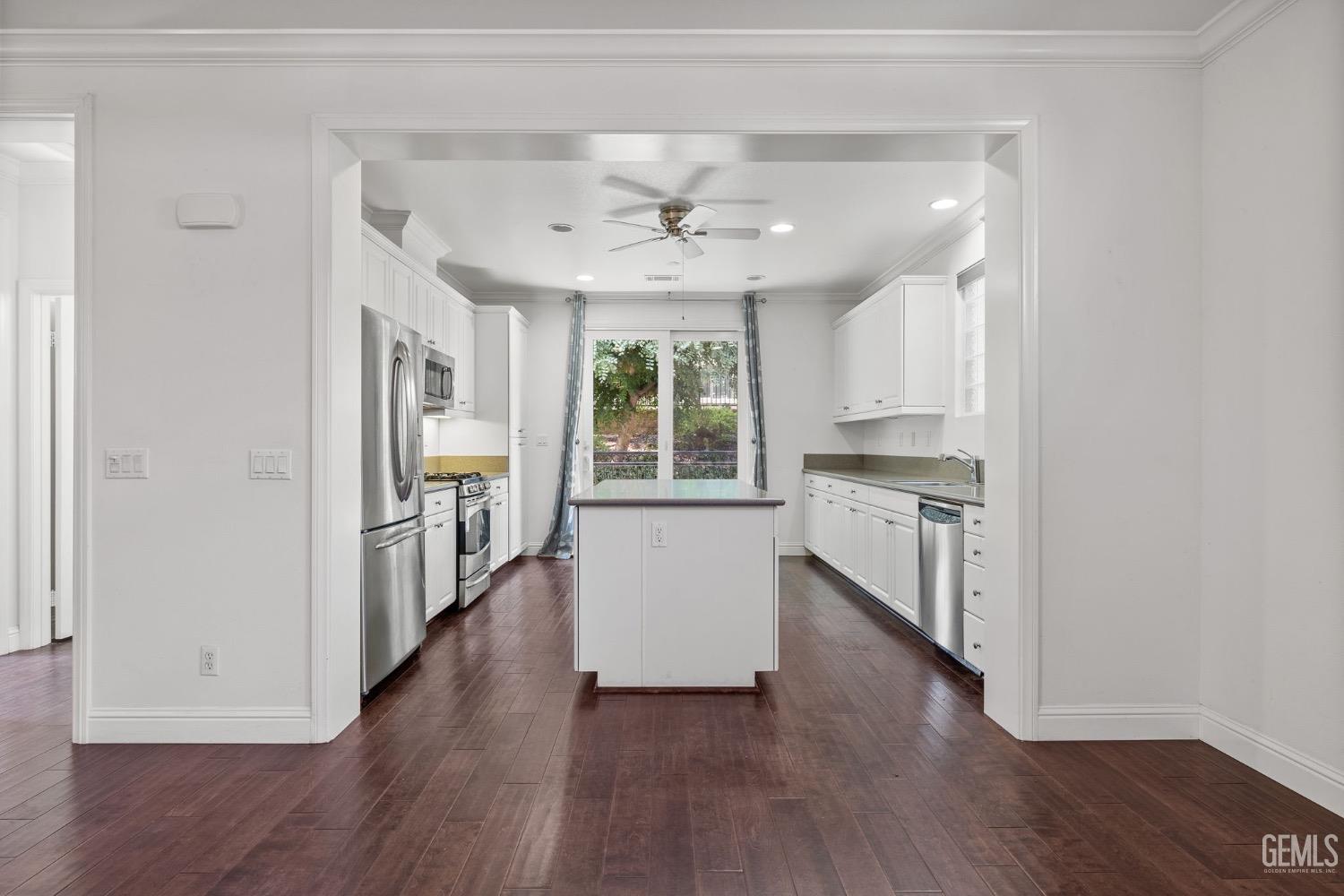 Undisclosed Address Bakersfield, CA 93306 - Photo 7 of 54 an empty room with wooden floor a ceiling fan and windows